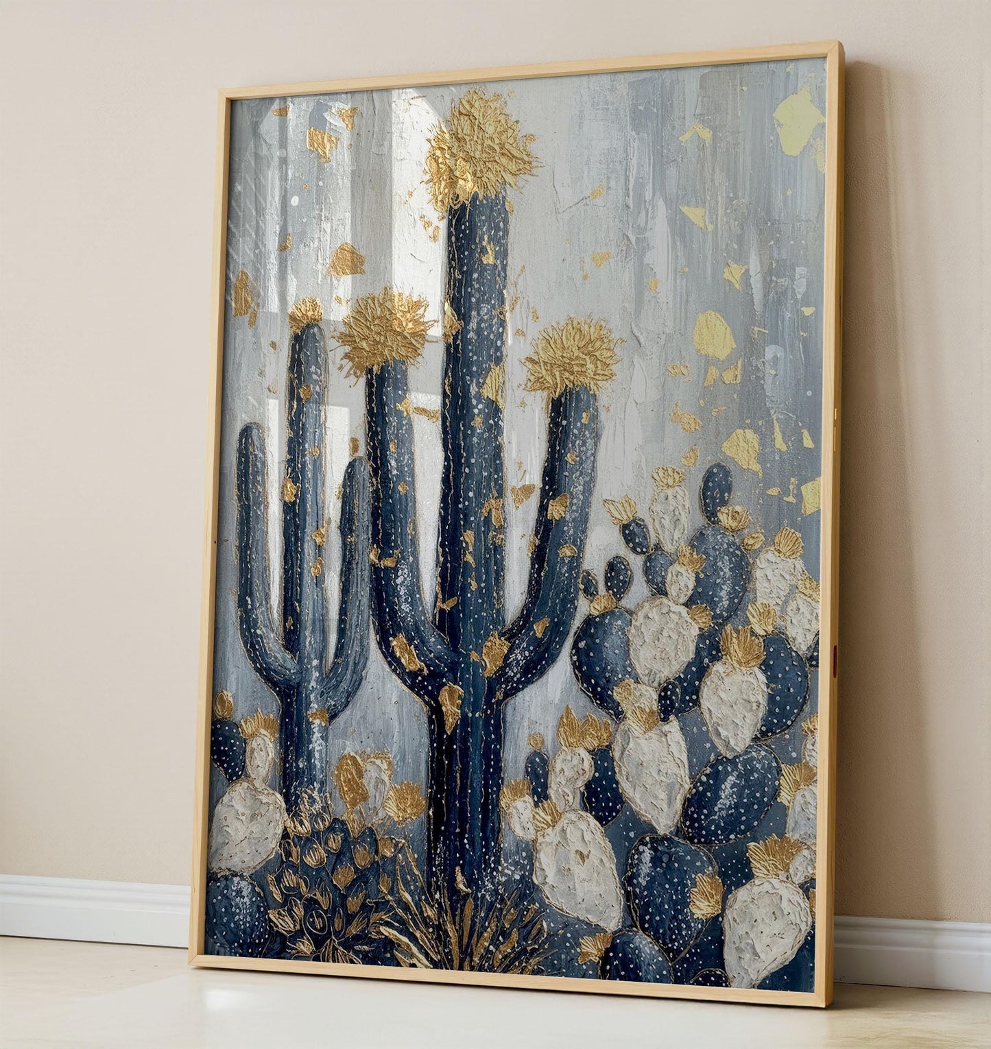 A highly textured 3D oil painting of saguaro and prickly pear cacti in navy blue and white. The artwork features thick sculptural gold leaf on the cactus flowers and scattered gold flakes across a gray textured background.